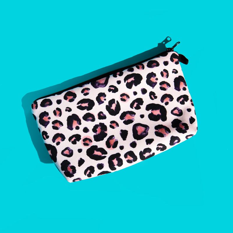 Turquoise background. There is a pale pink oblong shaped pouch (for carrying spare or used pairs) with a black and pink leopard print design.