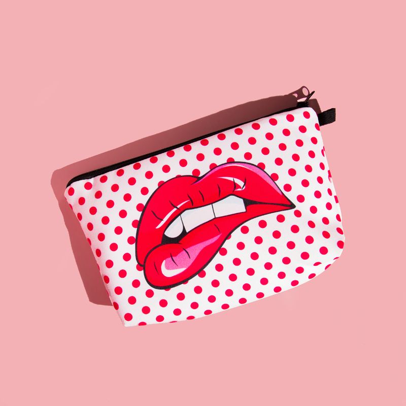 Pink background.  There is a white oblong shaped pouch (for carrying spare or used pairs) with red polka dots and a pair of large red lips in the middle in a pop art style.